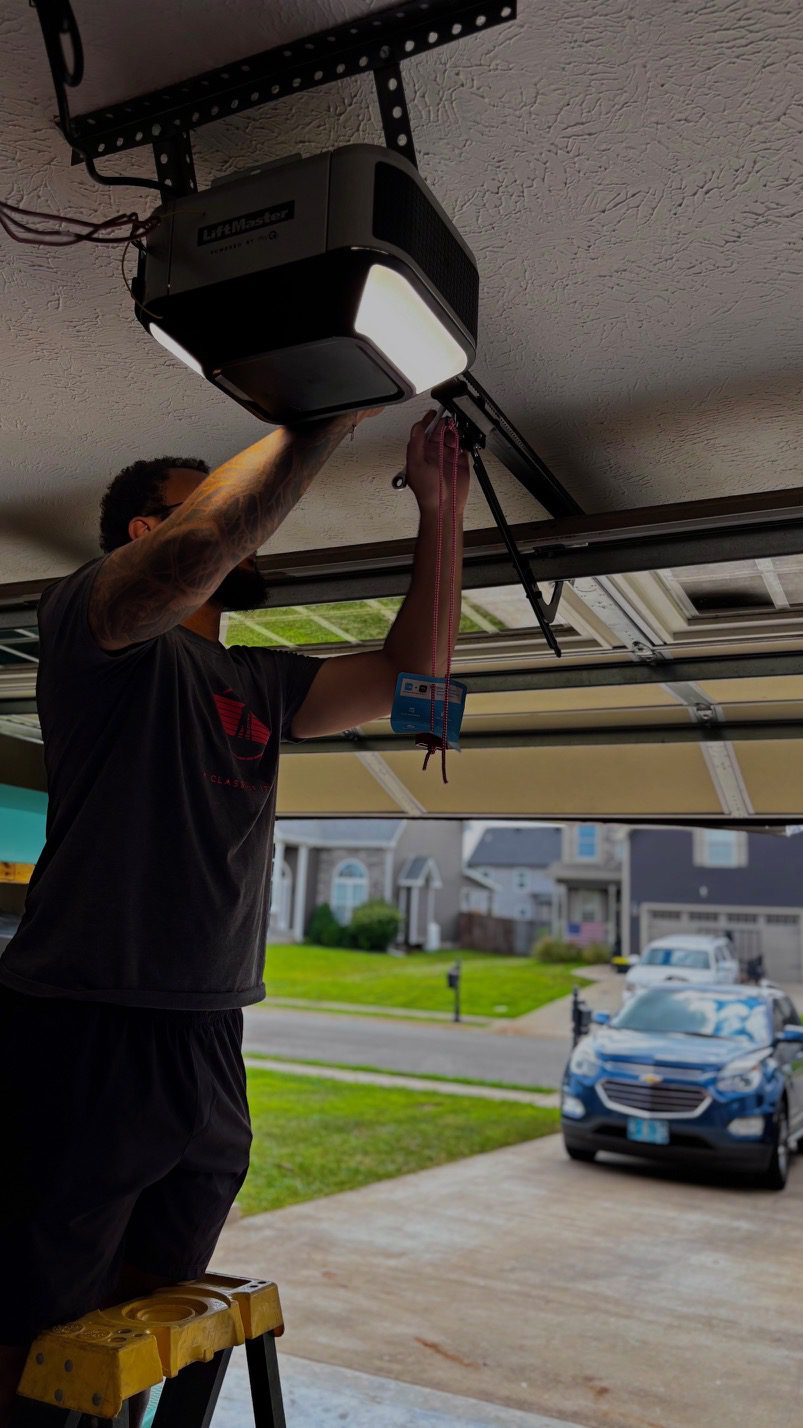 Technician performing garage door maintenance working on opener system